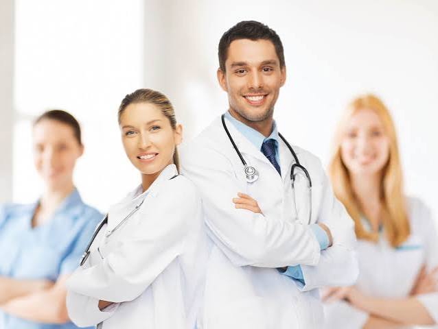 Three clinicians standing together, arms crossed