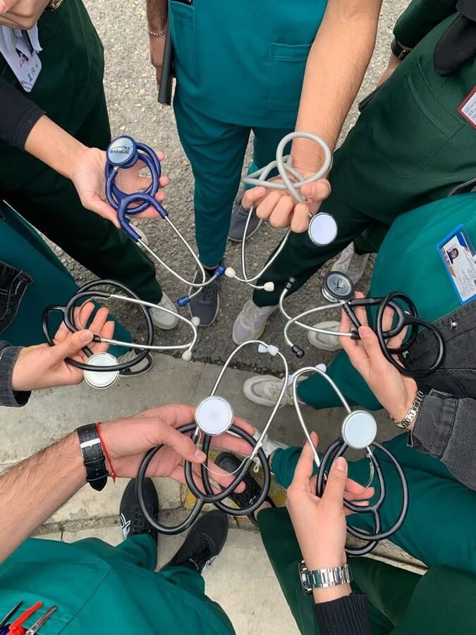 Clinicians huddled with stethoscopes